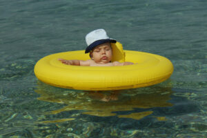 Baby sleeping in a floaty in the water